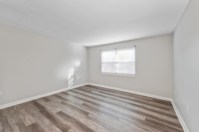 spare room featuring wood-type flooring and a textured ceiling