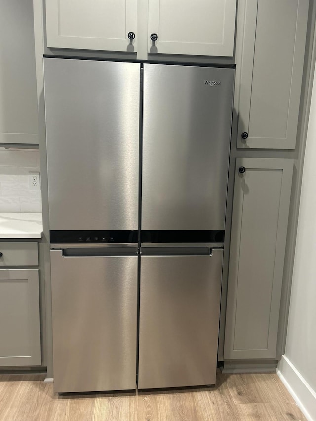 room details featuring stainless steel refrigerator, gray cabinetry, and light hardwood / wood-style floors