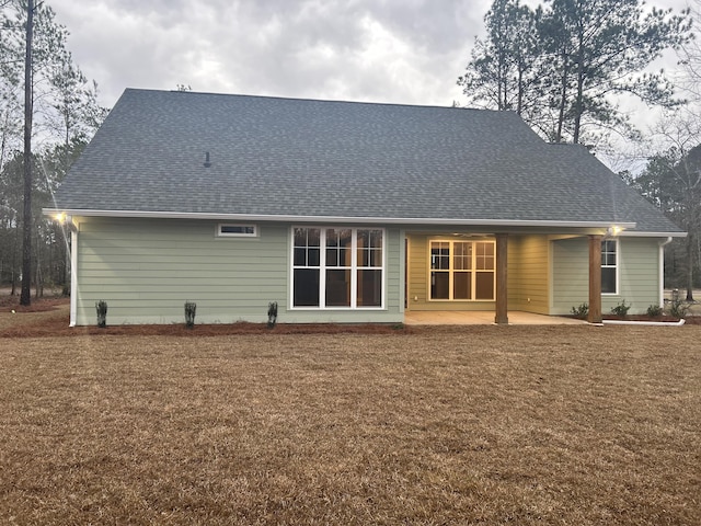 rear view of house featuring a patio and a yard