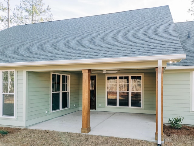rear view of property with a patio and a shingled roof