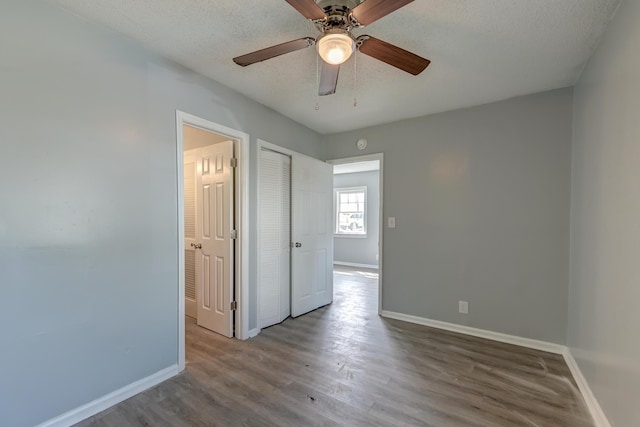 unfurnished room with a textured ceiling and baseboards