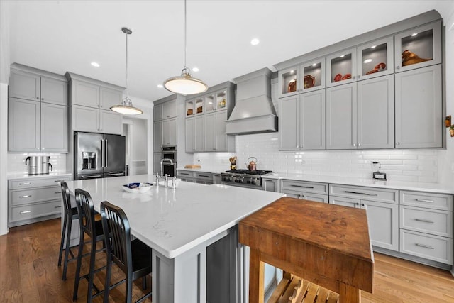 1962 Bellona St, Charleston, SC 29492 - kitchen with custom range hood, appliances with stainless steel finishes, gray cabinets, and wood finished floors