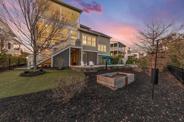 1962 Bellona St, Charleston, SC 29492 - back of property featuring a lawn, a patio, a balcony, a fenced backyard, and stairway