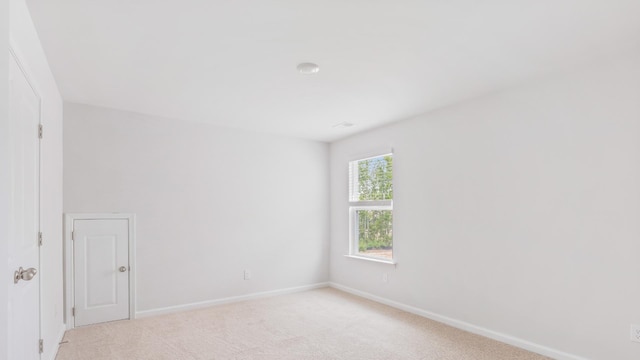 unfurnished room featuring light colored carpet