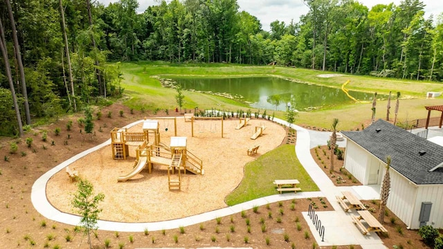 surrounding community with a playground, a lawn, and a water view