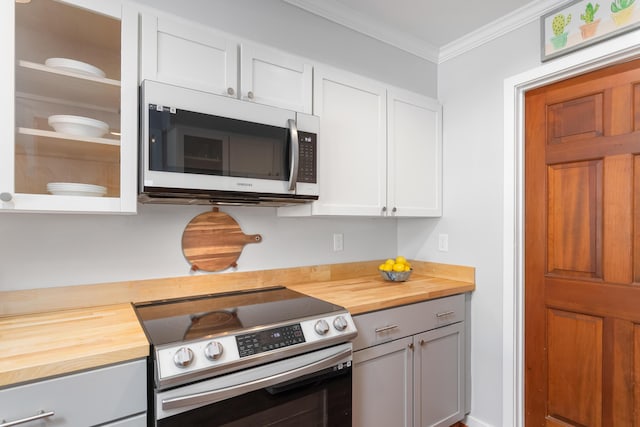 kitchen featuring wooden counters, stainless steel appliances, white cabinets, and ornamental molding