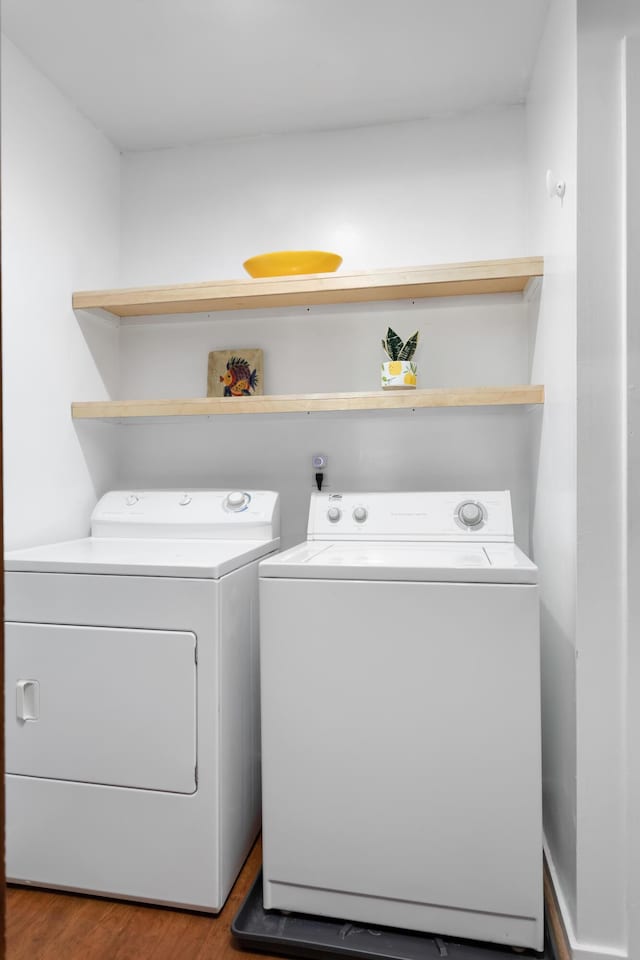 clothes washing area featuring washer and clothes dryer and hardwood / wood-style flooring