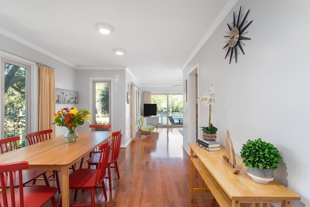 dining space featuring hardwood / wood-style flooring and crown molding