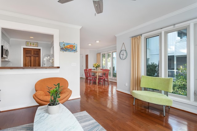 living room featuring ceiling fan, hardwood / wood-style floors, and ornamental molding