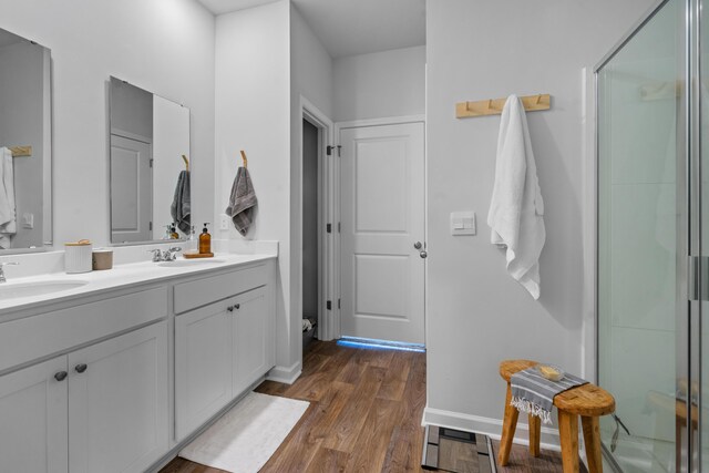 bathroom with hardwood / wood-style flooring, walk in shower, and vanity