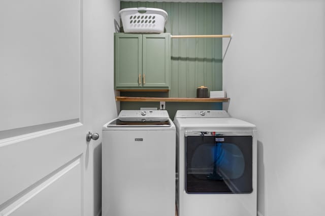 laundry room with washer and dryer and cabinets