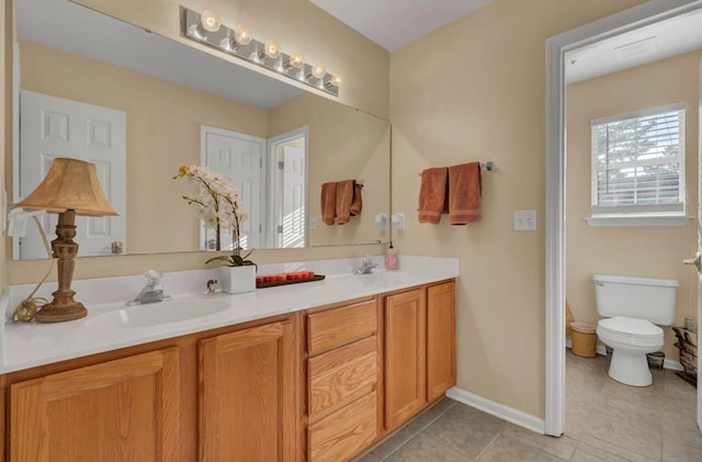 bathroom with toilet, vanity, and tile patterned floors