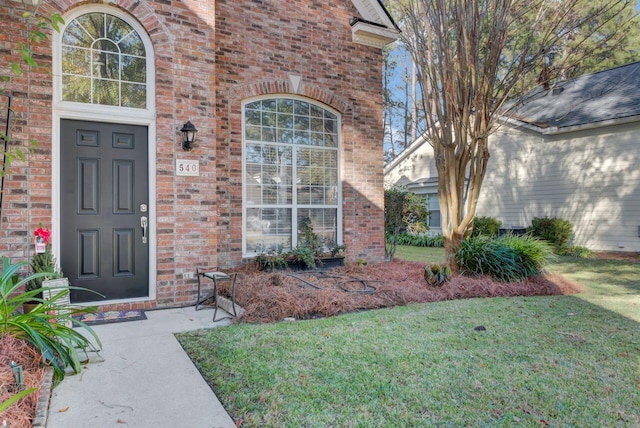 entrance to property with a lawn