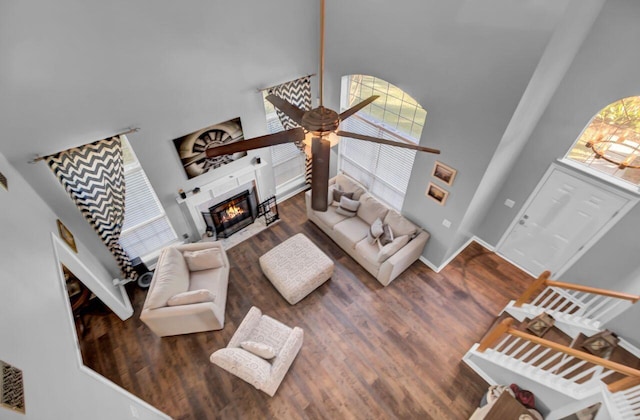 living room with dark hardwood / wood-style flooring, high vaulted ceiling, and ceiling fan