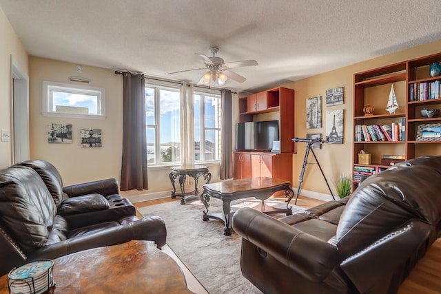 living room with ceiling fan and a textured ceiling