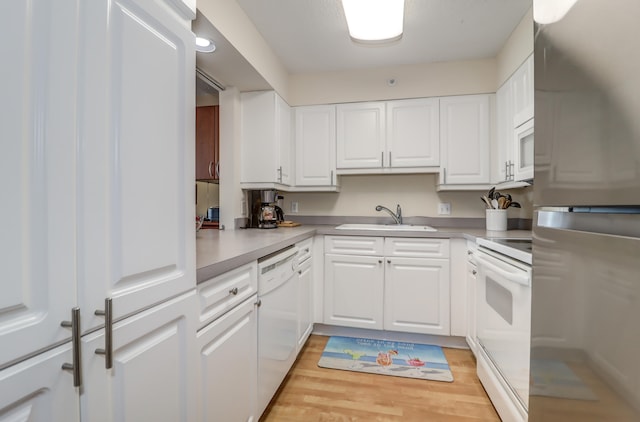 kitchen featuring white cabinets, light hardwood / wood-style floors, sink, and white appliances