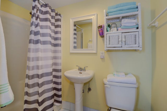 bathroom featuring walk in shower and toilet