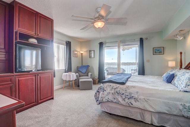 bedroom with ceiling fan, light colored carpet, and access to outside