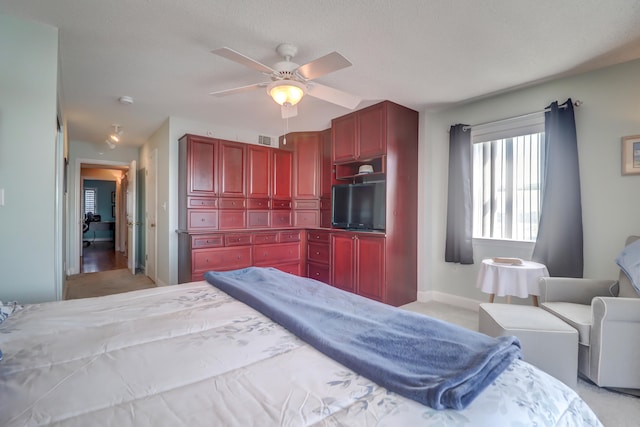 carpeted bedroom featuring ceiling fan and a textured ceiling