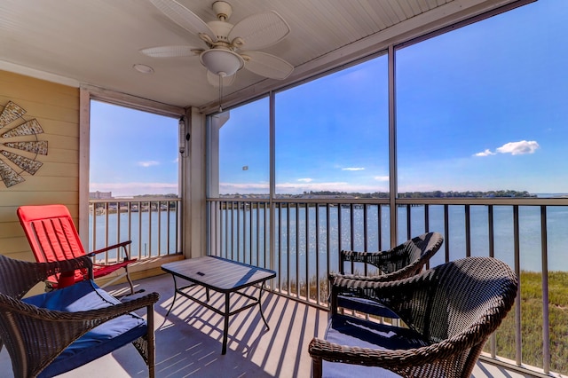 sunroom featuring ceiling fan, a water view, and a wealth of natural light