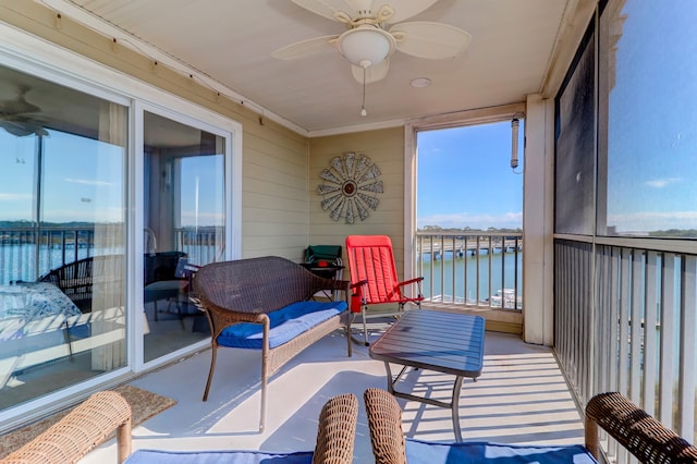 sunroom / solarium featuring a water view and ceiling fan