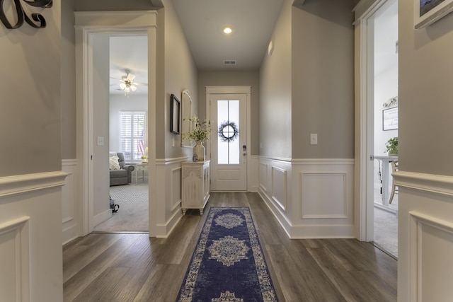 entrance foyer featuring dark wood-style floors, a ceiling fan, a wainscoted wall, recessed lighting, and a decorative wall