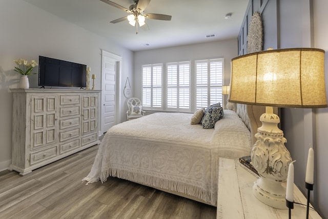 bedroom with wood finished floors, ceiling fan, and baseboards