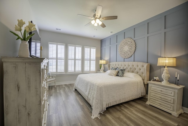 bedroom featuring multiple windows, baseboards, and wood finished floors