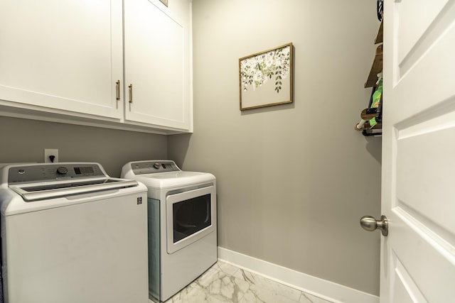 laundry area with washer and dryer, light marble finish floors, cabinet space, and baseboards