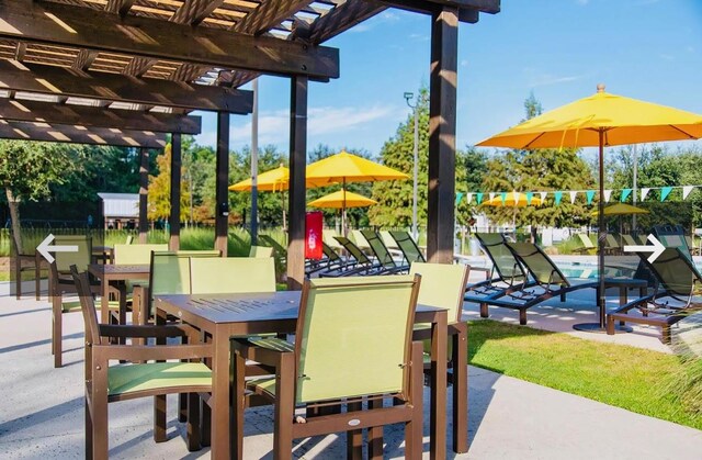 view of playground with a pergola, a patio area, a swimming pool, outdoor dining space, and fence