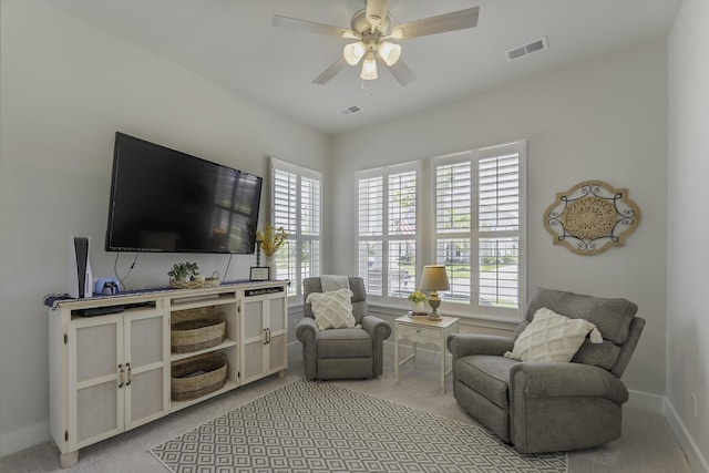 carpeted living area featuring ceiling fan and baseboards