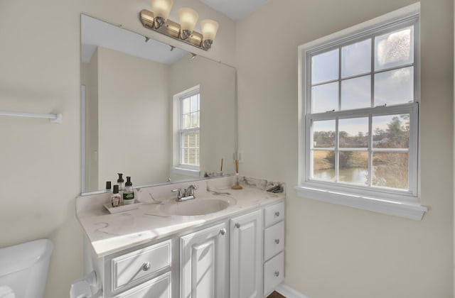 bathroom featuring vanity, toilet, and plenty of natural light