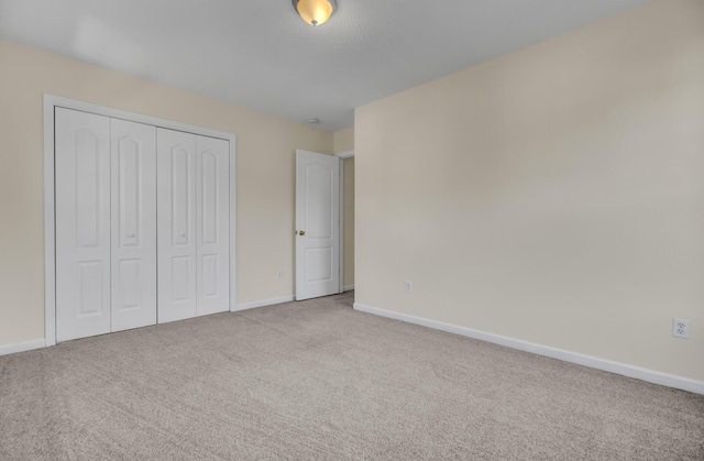 unfurnished bedroom featuring a closet and light colored carpet