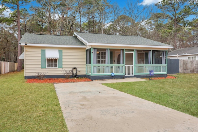 single story home featuring a sunroom and a front yard