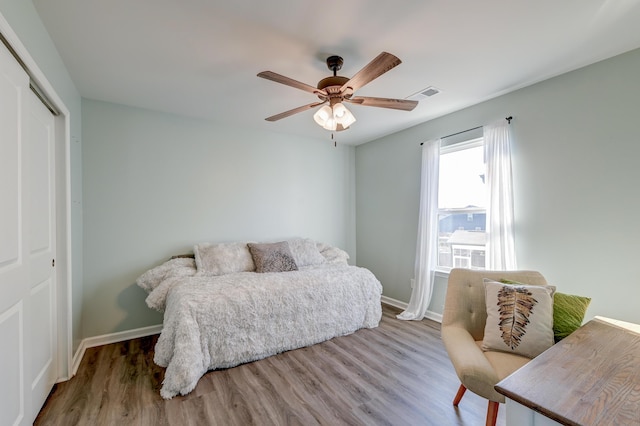 bedroom with hardwood / wood-style flooring, ceiling fan, and a closet