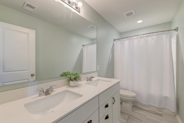 bathroom featuring curtained shower, vanity, and toilet