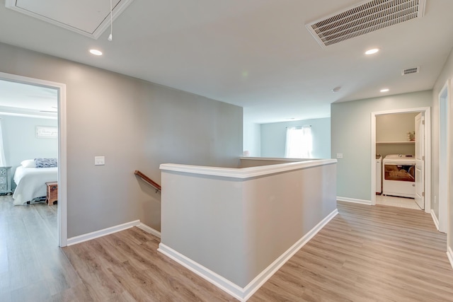 hallway with washing machine and dryer and light hardwood / wood-style floors