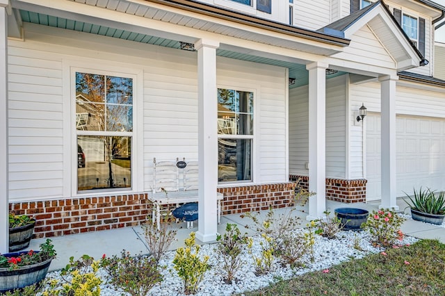 entrance to property featuring covered porch and a garage