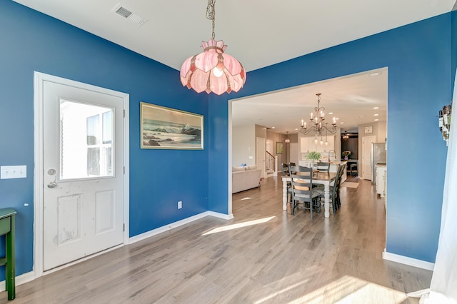 dining room featuring light hardwood / wood-style floors and a notable chandelier