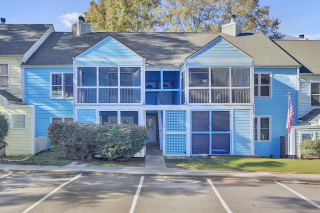 view of front of house with uncovered parking and a chimney