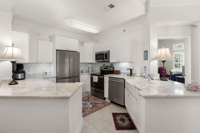 kitchen featuring white cabinets, ornamental molding, light tile patterned floors, kitchen peninsula, and stainless steel appliances