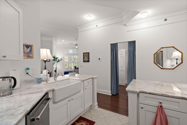 kitchen featuring light tile patterned flooring, sink, crown molding, stainless steel dishwasher, and light stone countertops