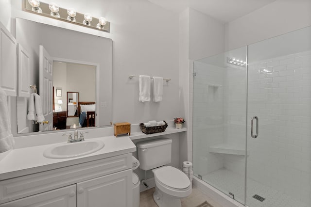 bathroom featuring vanity, toilet, and an enclosed shower