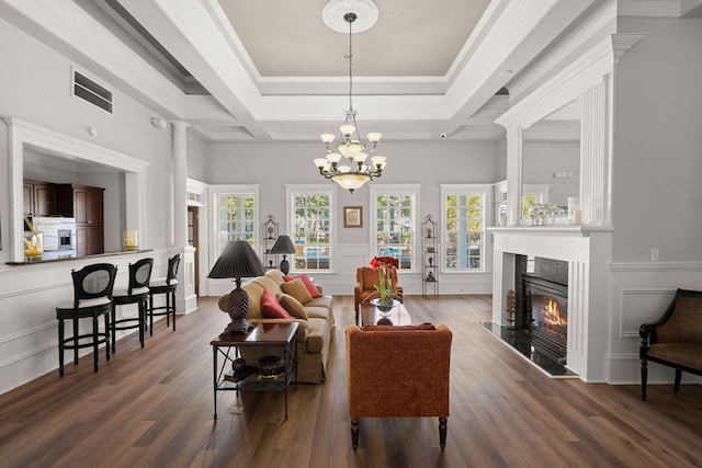 living room with a raised ceiling, crown molding, dark hardwood / wood-style floors, and a high end fireplace