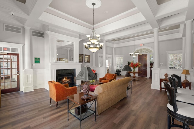 living room with beamed ceiling, dark wood-type flooring, decorative columns, and a notable chandelier