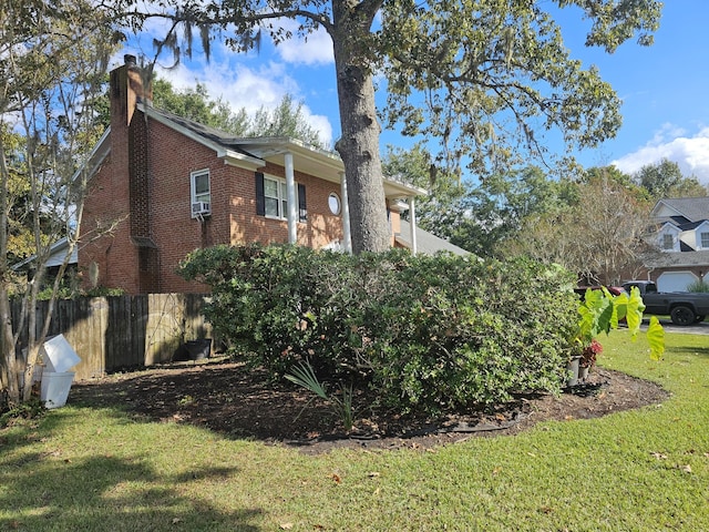 view of side of home with cooling unit and a lawn