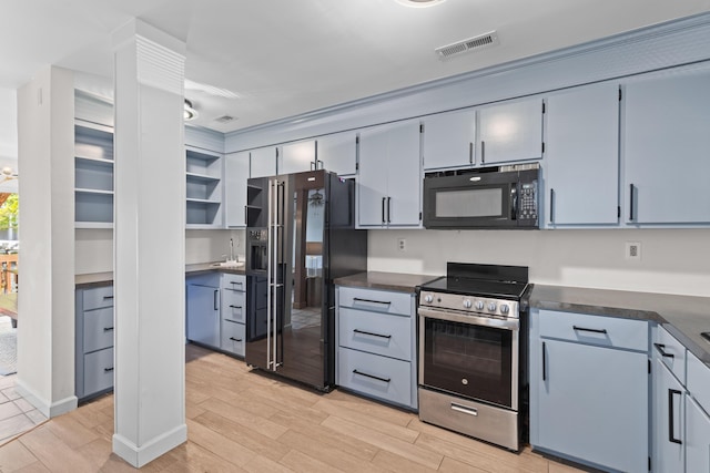 kitchen featuring visible vents, black appliances, wood finish floors, and dark countertops