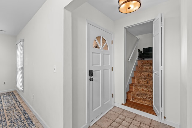 foyer with stairway and baseboards