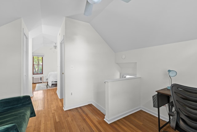 office space with baseboards, radiator, lofted ceiling, wood-type flooring, and ceiling fan