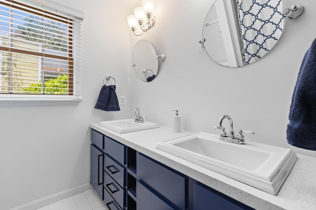 full bathroom featuring double vanity, baseboards, and a sink